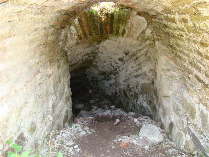 Поглед навътре към тунела, водещ до воден поток в прилежащата урва